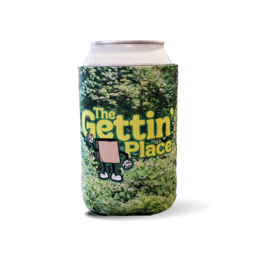 A slim can cooler sleeve wrapped around a can, featuring a green kudzu pattern with the yellow text 'The Gettin' Place' and a small cartoon character, shown on a white background.